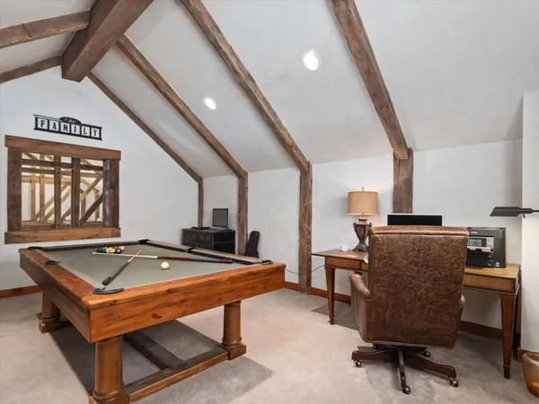 a room with furniture pool table and windows