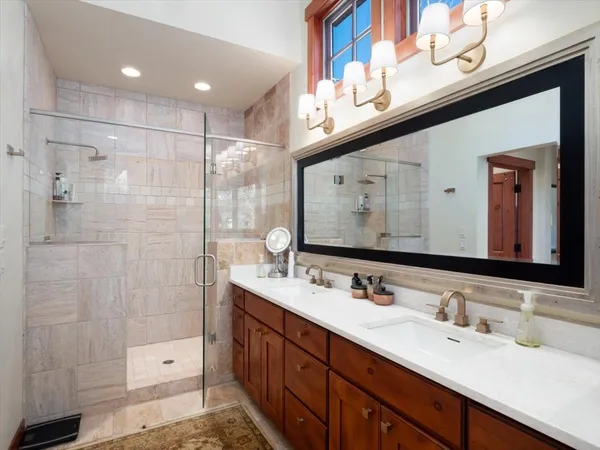 a bathroom with a double vanity sink mirror double and shower