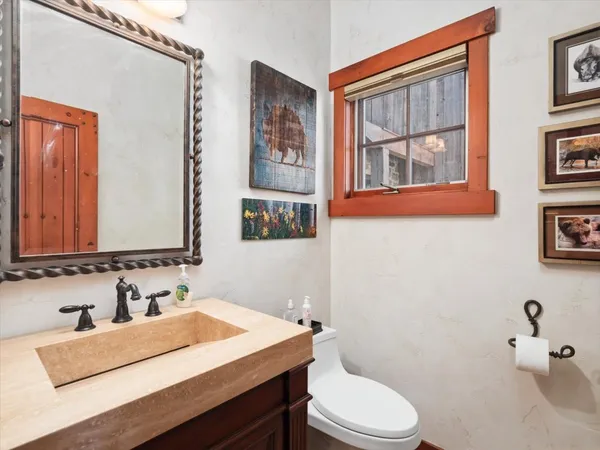 a bathroom with a sink vanity mirror and toilet