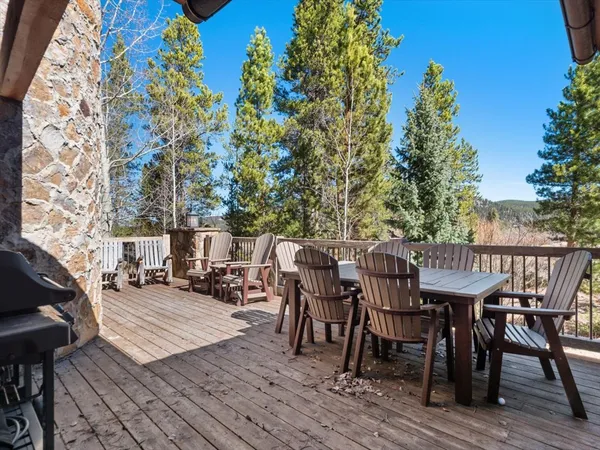 a view of a roof deck with table and chairs with wooden floor and fence
