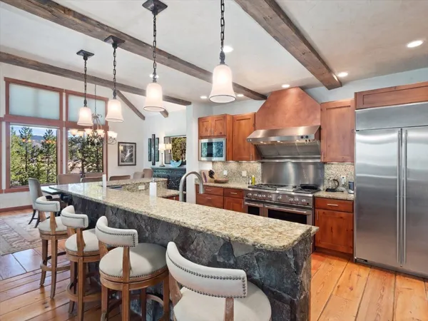 a kitchen with stainless steel appliances granite countertop a sink a stove and a refrigerator