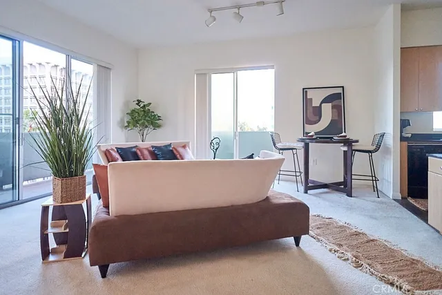 a living room with furniture a large window and potted plants