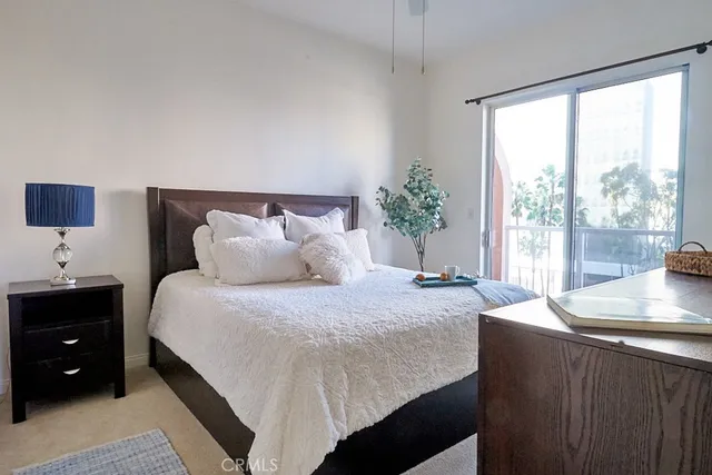 a bedroom with a large bed and a potted plant