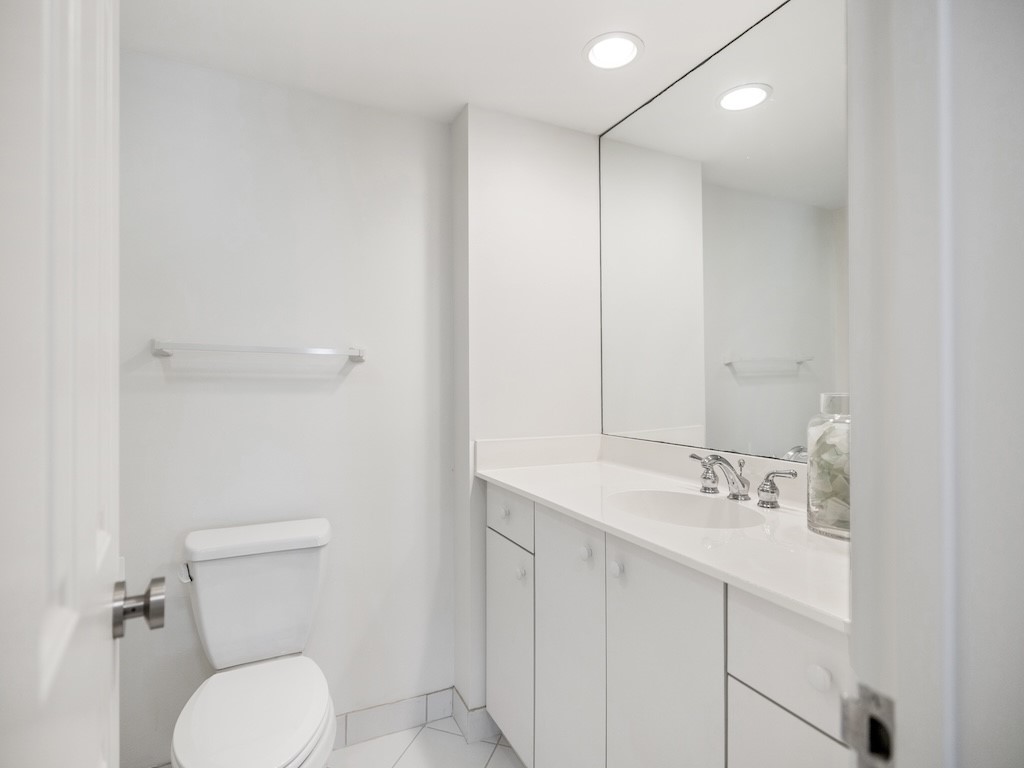 1180 Reef Road, Unit A24 Vero Beach, FL 32963 - Photo 16 of 26 a bathroom with a sink a toilet and mirror