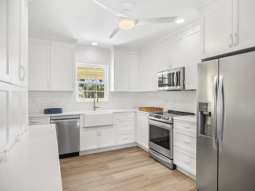 1180 Reef Road, Unit A24 Vero Beach, FL 32963 - Photo 8 of 26 a kitchen with a stove a sink and a refrigerator