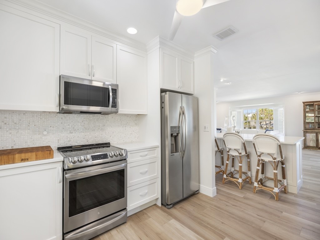 1180 Reef Road, Unit A24 Vero Beach, FL 32963 - Photo 9 of 26 a kitchen with a refrigerator stove and wooden cabinets
