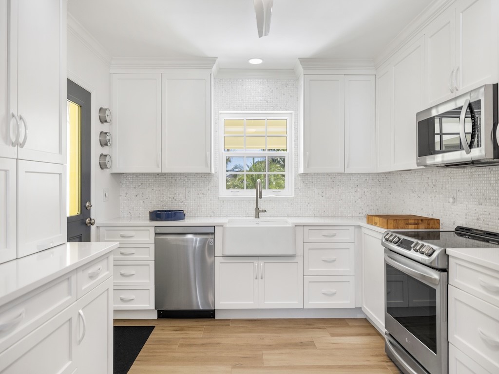 1180 Reef Road, Unit A24 Vero Beach, FL 32963 - Photo 10 of 26 a kitchen with stainless steel appliances white cabinets and a stove top oven