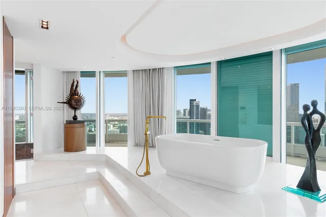 a living room with couch a flat screen tv and a large window