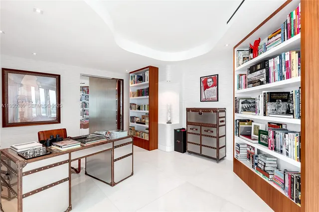 a living room with furniture a flat screen tv and a refrigerator