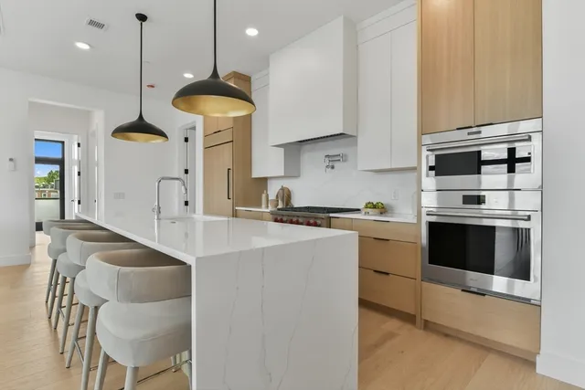 a kitchen with stainless steel appliances granite countertop a stove a sink and a refrigerator