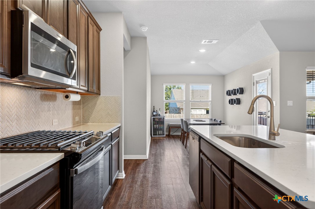 1036 View Drive Georgetown, TX 78628 - Photo 4 of 33 a kitchen with stainless steel appliances granite countertop a sink stove and microwave
