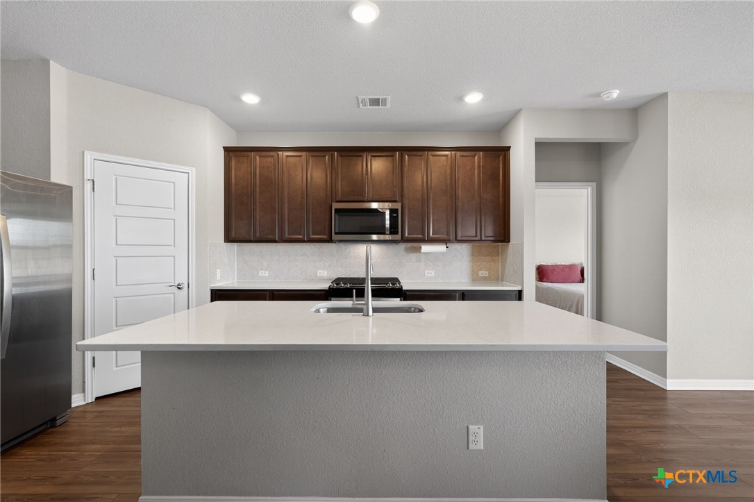 1036 View Drive Georgetown, TX 78628 - Photo 5 of 33 a kitchen with kitchen island granite countertop a sink and a refrigerator