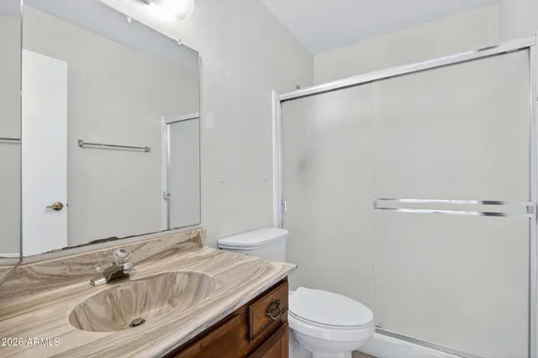 a bathroom with a sink a toilet and a mirror