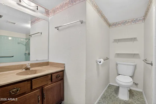 a bathroom with a granite countertop toilet and a sink