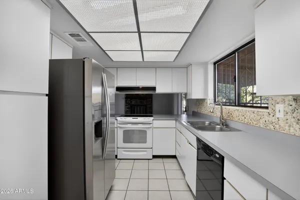 a kitchen with stainless steel appliances a refrigerator sink and microwave