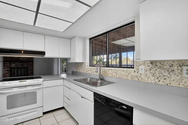 a kitchen with granite countertop a sink stainless steel appliances and cabinets