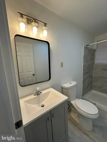 a bathroom with a sink mirror vanity and toilet