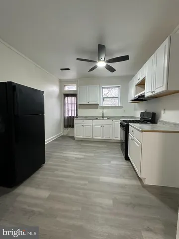 a large kitchen with stainless steel appliances granite countertop a stove and a refrigerator