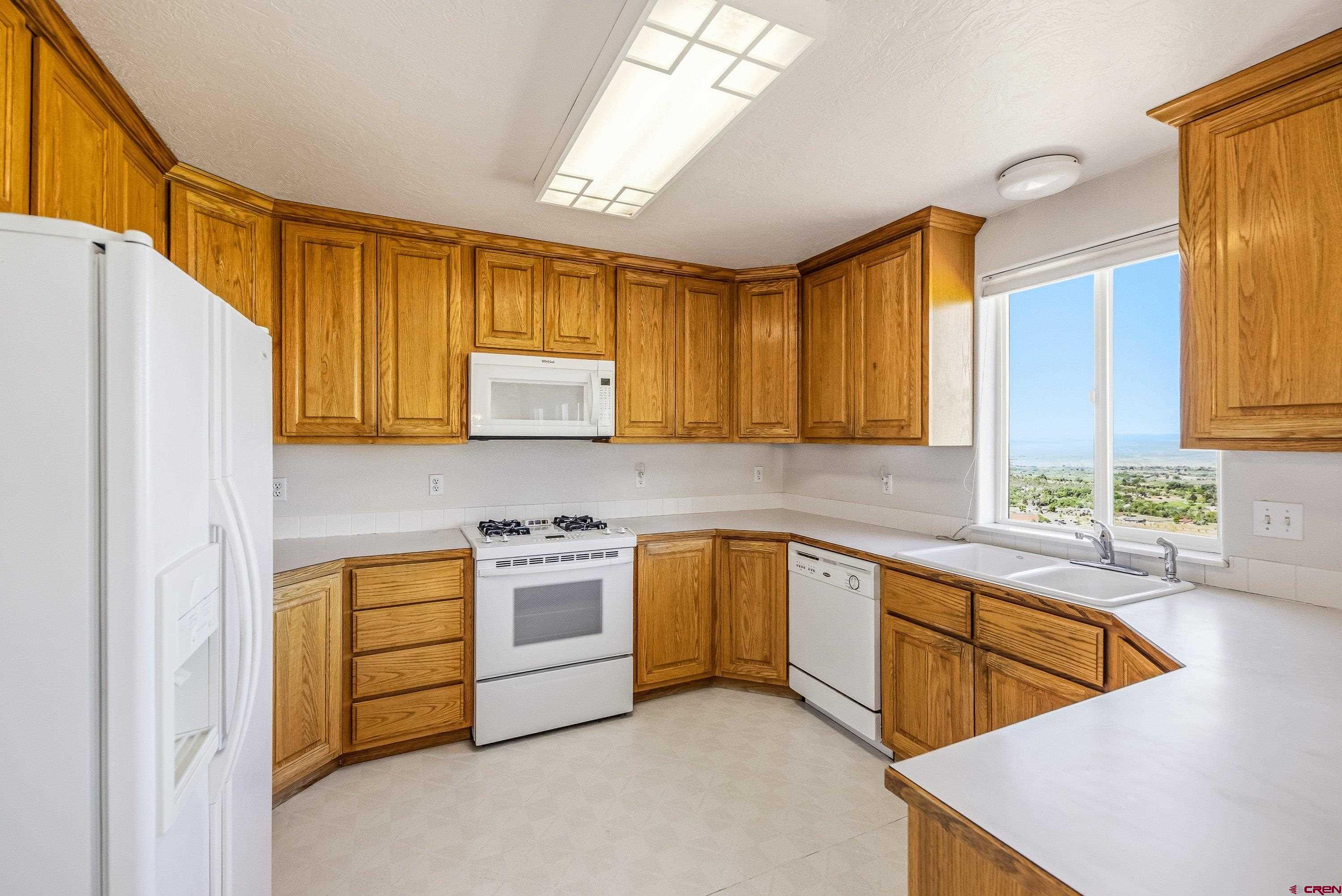 24239 Valley View Circle Cedaredge, CO 81413 - Photo 4 of 18 a kitchen with stainless steel appliances granite countertop a sink a stove and a refrigerator