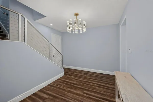 a living room with a balcony a couch and a dining table with a large window
