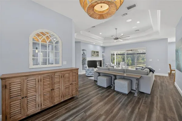 a kitchen with stainless steel appliances kitchen island granite countertop a dining table chairs and a refrigerator