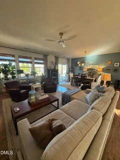 a living room with furniture kitchen view and large windows