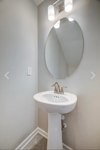 a bathroom with a sink a mirror and lamp