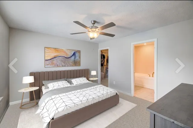 a bedroom with a large bed and a chandelier