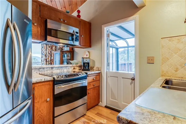 a kitchen with stainless steel appliances granite countertop a stove a sink and a refrigerator