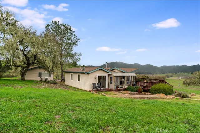 a view of a yard with table and chairs under an umbrella