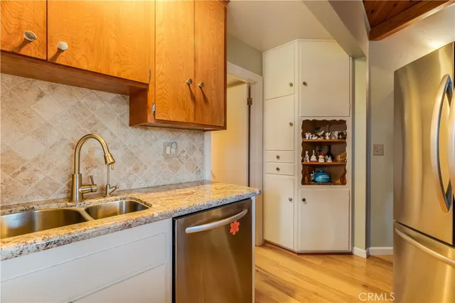 a kitchen with stainless steel appliances granite countertop a sink a refrigerator and a stove