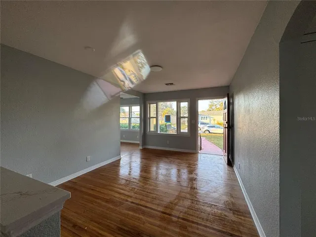 wooden floor in an empty room with a window