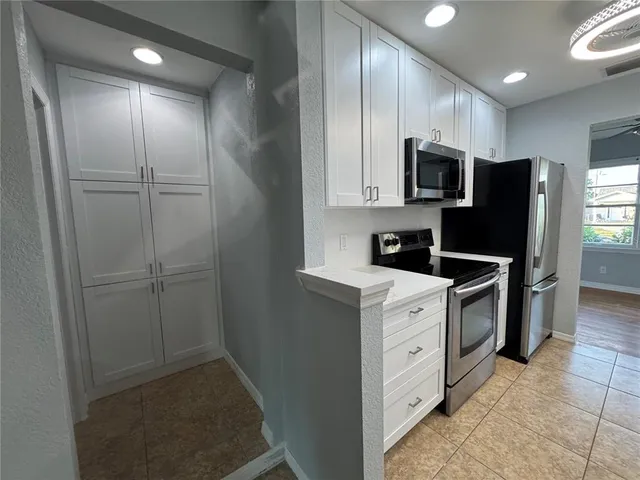 a kitchen with a refrigerator a sink and cabinets