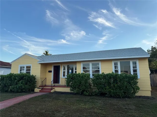 a front view of a house with a yard and trees