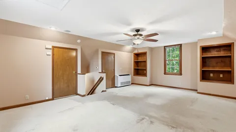 a bedroom with a large bed couch and a window