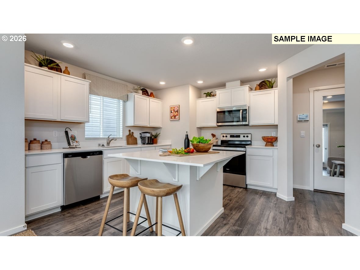105 Coho Loop Woodland, WA 98674 - Photo 6 of 27 a kitchen with appliances a sink a counter top space and cabinets