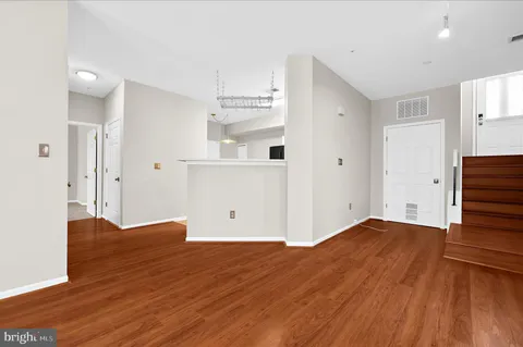a view of empty room with wooden floor and window