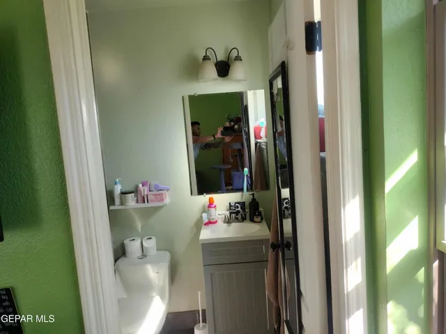 a bathroom with a mirror sink and toilet