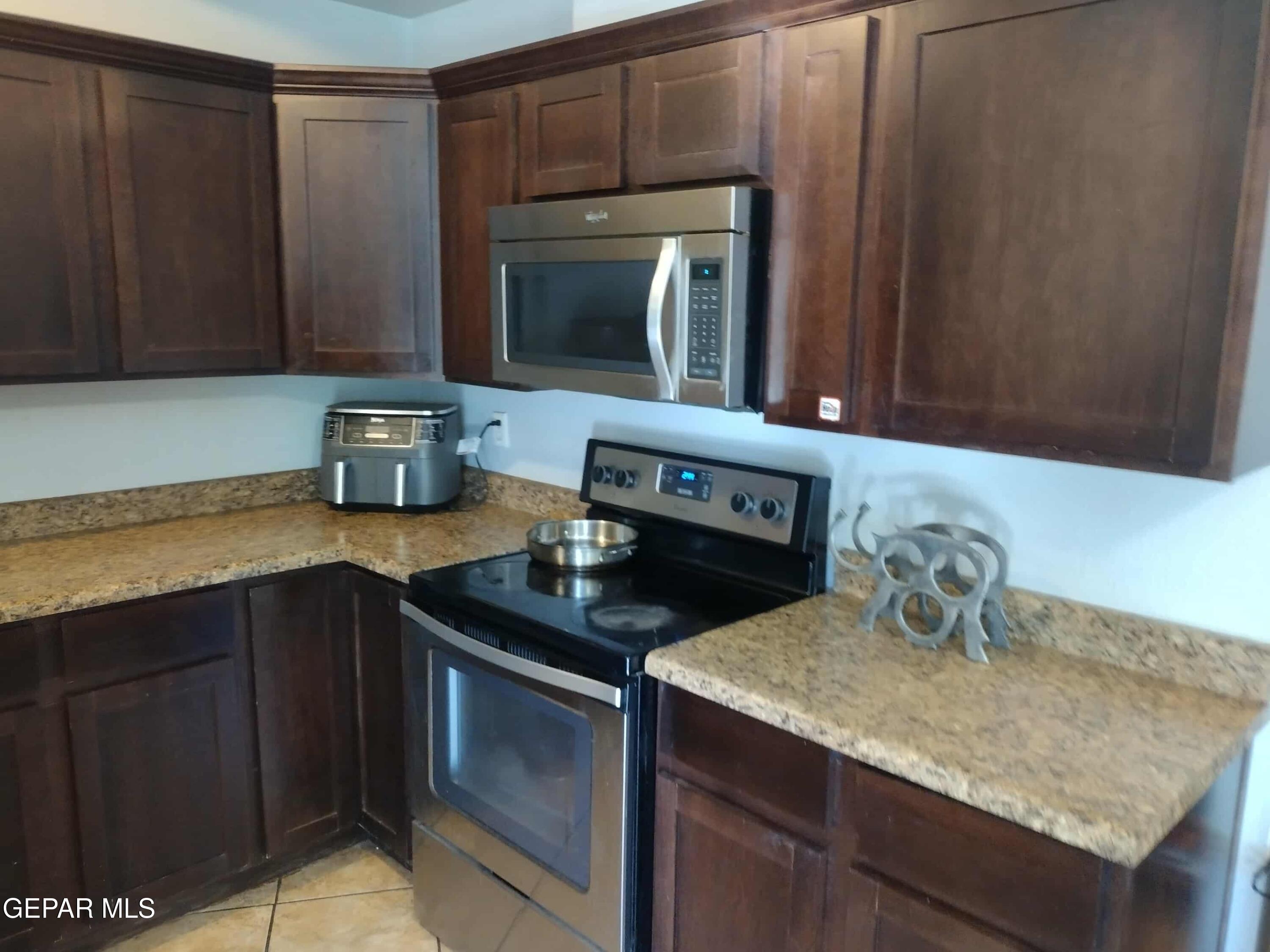 3307 Donegal Road El Paso, TX 79925 - Photo 7 of 21 a kitchen with granite countertop a sink dishwasher stove and microwave oven