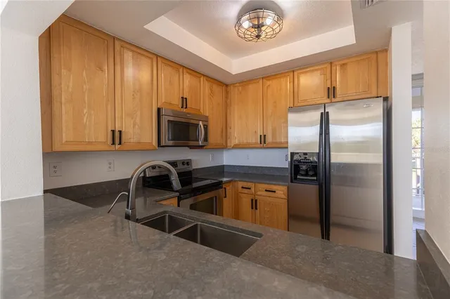 a kitchen with refrigerator a microwave a sink and cabinets