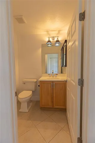 a bathroom with a granite countertop sink mirror vanity and toilet