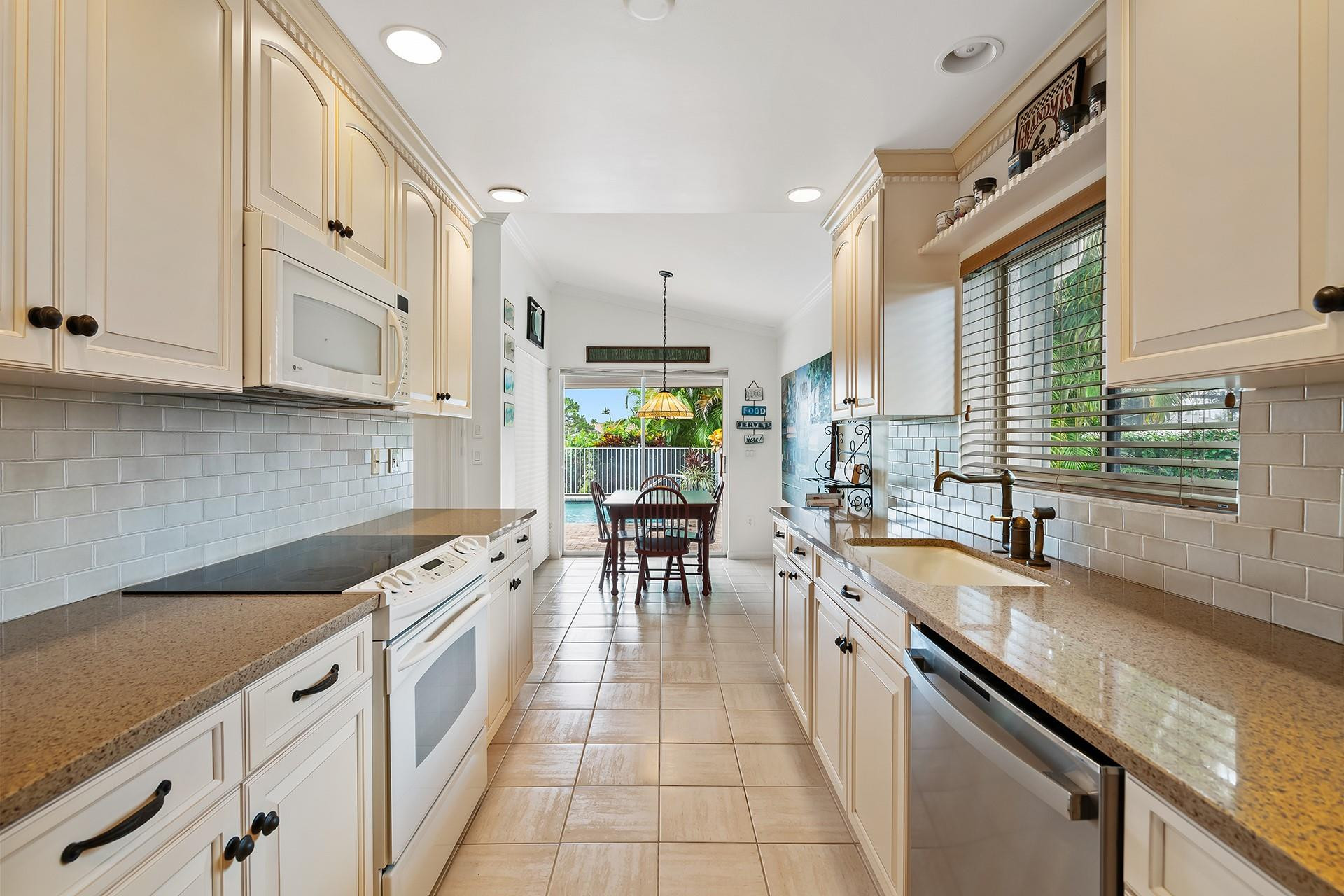 10344 Sunset Bend Drive Boca Raton, FL 33428 - Photo 13 of 32 a kitchen with stainless steel appliances granite countertop a sink and cabinets