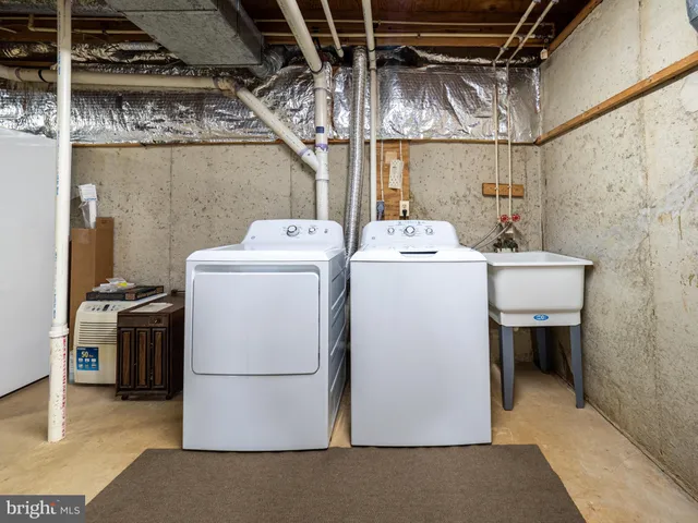 a view of a white house with large windows and a small yard