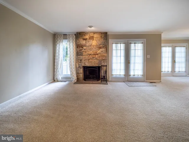 a view of a big room with windows and chandelier fan