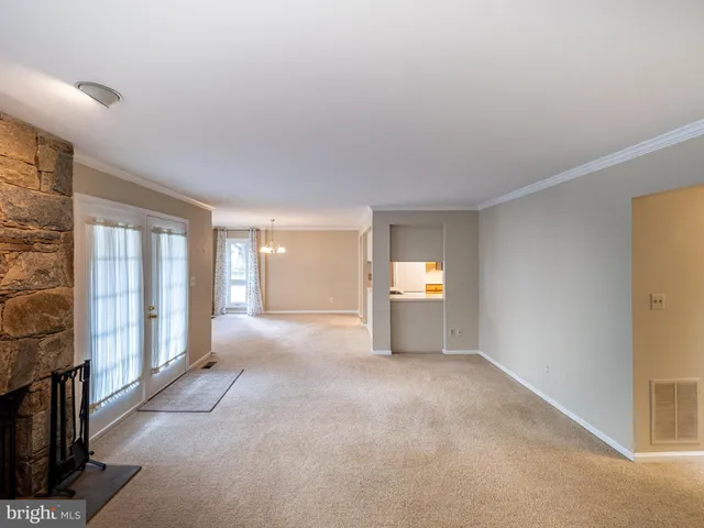 a view of an empty room with a fireplace and a window
