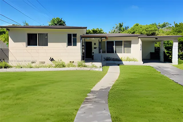 a front view of a house with a garden and yard