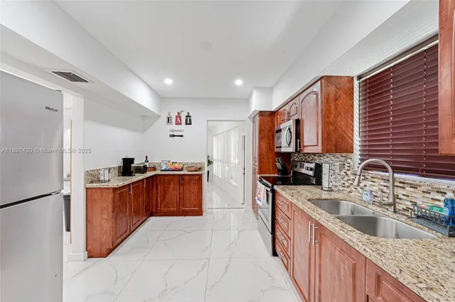 a kitchen with stainless steel appliances granite countertop a sink stove and refrigerator