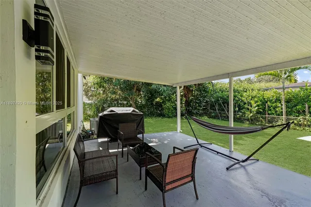 a view of a patio with a table chairs and a yard