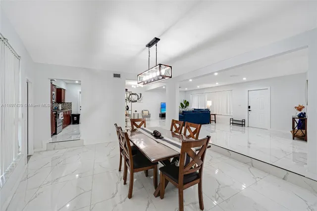 a view of a dining room with furniture and a chandelier