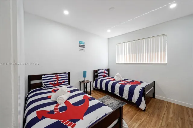 a bedroom with two beds and a chair